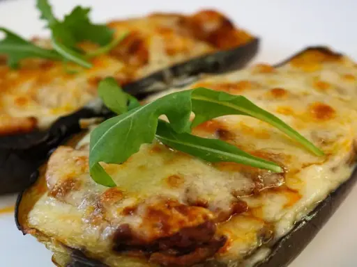 Melanzane ripiene al forno, un sapore autentico di mangiare calabrese, guarnite con rucola fresca.