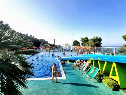 Sole, piscina e divertimento al camping Riva Verde Marche. Famiglie e bambini si godono l'acqua cristallina e il relax sotto gli ombrelloni.