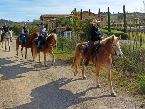 Cavalcata in un maneggio toscana, tra colline verdi e casali antichi.
