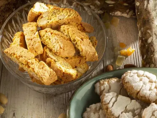Biscotti e amaretti, deliziosi dolci toscani, su un tavolo di legno.