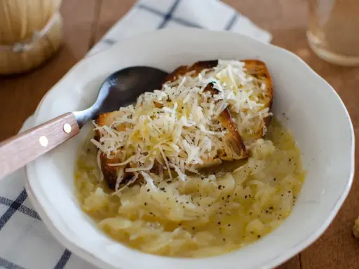 Zuppa di cipolle fumante con crostini gratinati al formaggio, un comfort food che ricorda la carabaccia.