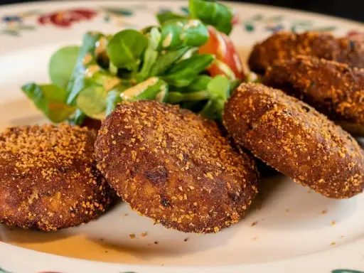 Crocchette dorate e croccanti, un classico su cosa mangiare in Lombardia, servite con un'insalatina fresca.
