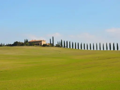Colline verdi toscane con cipressi e un casale, perfetto per un itinerario toscana 5 giorni da sogno.