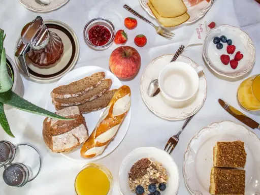 Un ricco e genuino **colazione contadina** con pane integrale, marmellata, frutta fresca, yogurt, succo d'arancia e dolcetti.