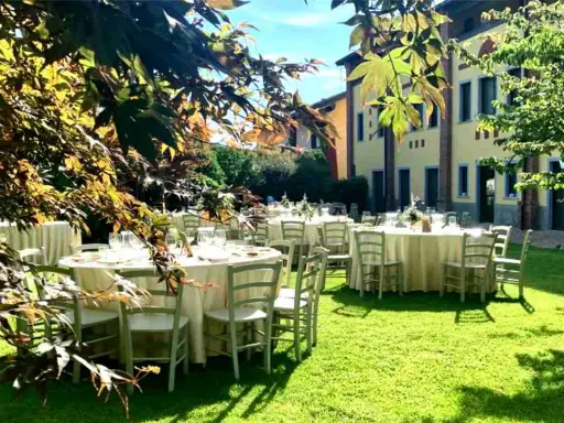 Tavoli apparecchiati in giardino, un'idea perfetta per cosa fare in campagna: un banchetto all'aperto sotto il sole.