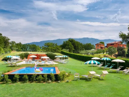 Agriturismi per bambini con piscina e gonfiabile a forma di unicorno, circondati da verde e colline.