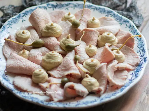 Fettine sottili di vitello con salsa tonnata e capperi, un classico delle specialità piemontesi.