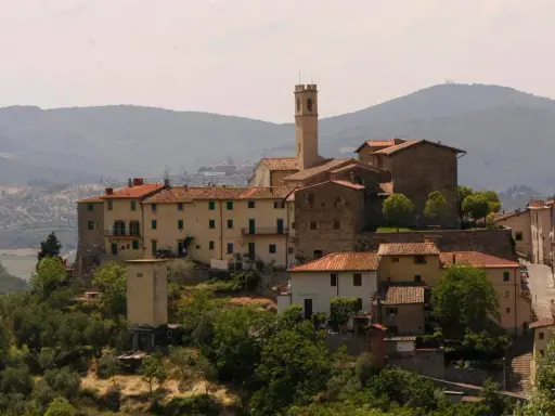 Borgo toscano con campanile, un luogo da film, dove la storia incontra la bellezza paesaggistica.