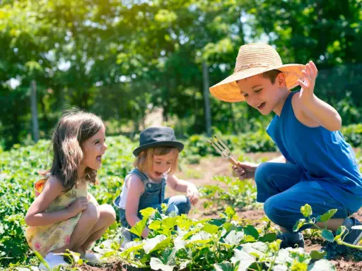 Bambini felici in un orto, un'esperienza divertente nelle fattorie per bambini nelle Marche.