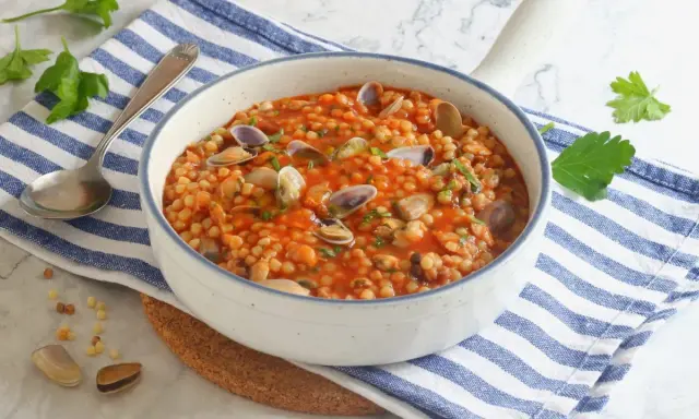 Fregola sarda con vongole e cozze, un classico da provare per scoprire cosa mangiare in Sardegna.