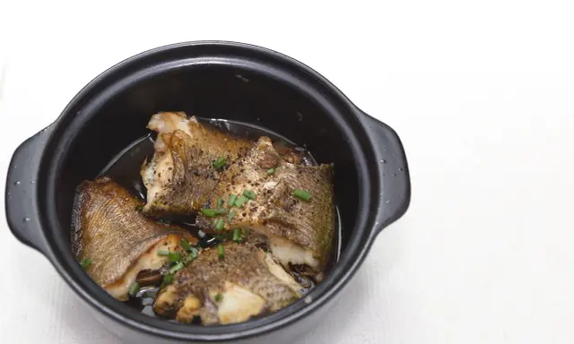 Pezzi di pesce dorato in umido, guarniti con erba cipollina, un assaggio dei piatti tipici Pescara.