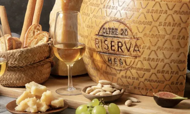 Momento di degustazione grana padano: formaggio stagionato, pane, uva, fichi e vino bianco.