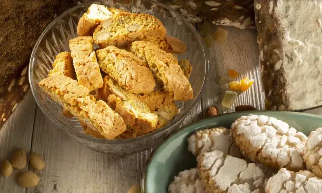 Biscotti e amaretti, deliziosi dolci toscani, su un tavolo di legno.