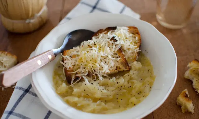 Zuppa di cipolle fumante con crostini gratinati al formaggio, un comfort food che ricorda la carabaccia.