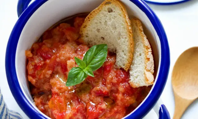 Pappa al pomodoro, un piatto che racconta la sua origine toscana. Servita in ciotola con pane raffermo, pomodoro e basilico fresco.