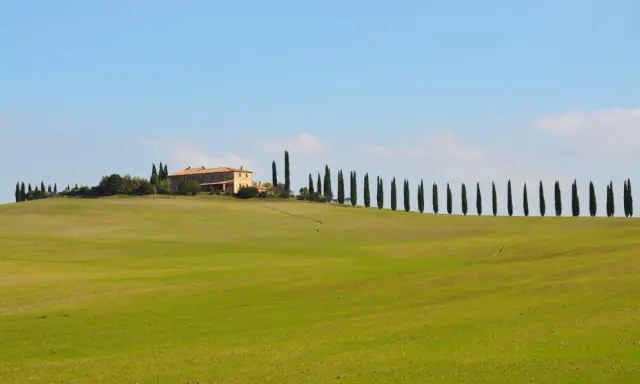 Colline verdi toscane con cipressi e un casale, perfetto per un itinerario toscana 5 giorni da sogno.