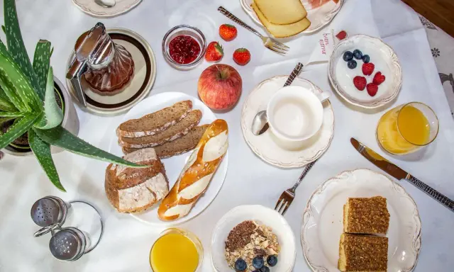 Un ricco e genuino **colazione contadina** con pane integrale, marmellata, frutta fresca, yogurt, succo d'arancia e dolcetti.