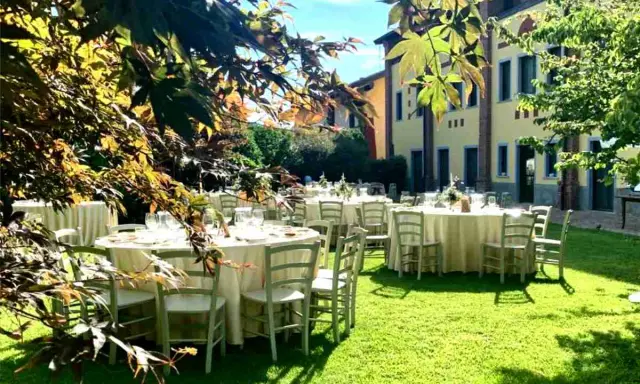 Tavoli apparecchiati in giardino, un'idea perfetta per cosa fare in campagna: un banchetto all'aperto sotto il sole.