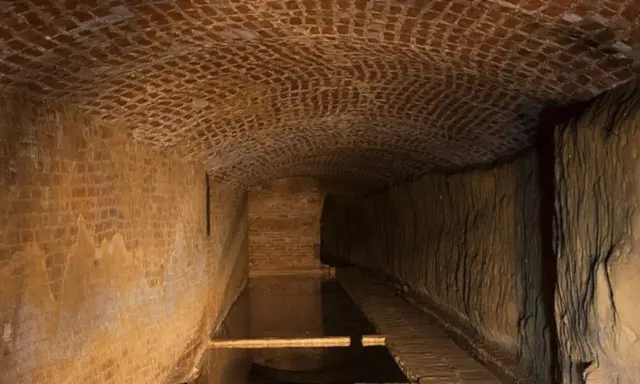 Antichi bottini di Siena, un labirinto sotterraneo di mattoni e terra, con un canale d'acqua.