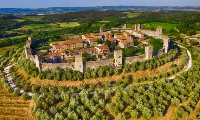 Borghi medievali vicino Firenze, un gioiello fortificato tra ulivi e vigneti, con torri e mura che raccontano storie antiche.