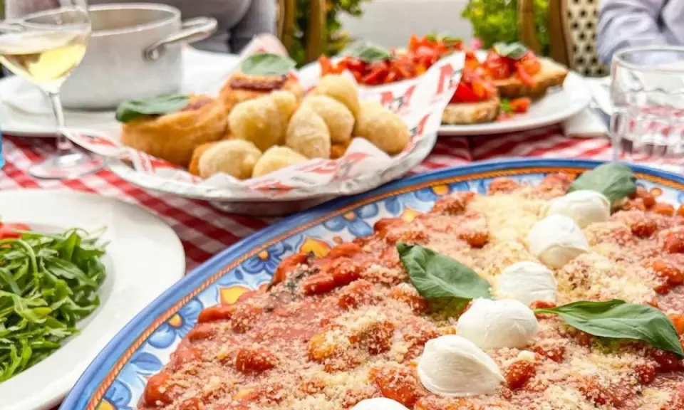 Un assaggio di cosa mangiare in Campania: gnocchi fritti, bruschette e un piatto di pasta al pomodoro e mozzarella.