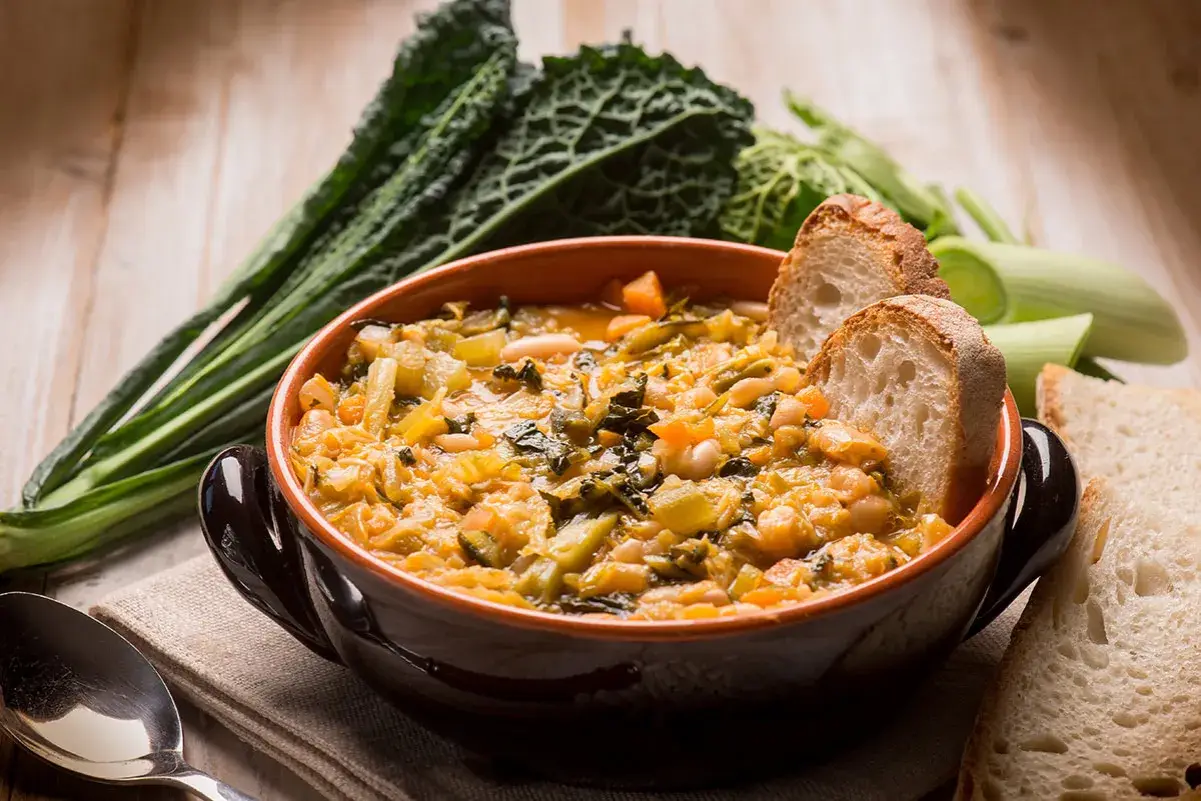 Zuppa di cavolo nero e fagioli, un classico dei piatti tipici toscani, servita con pane casereccio.