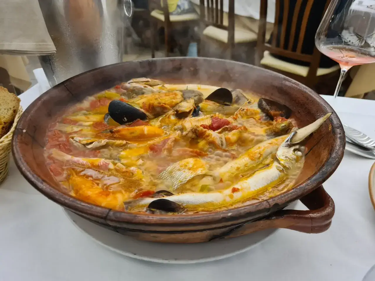 Un fumante tegame di terracotta con pesce, cozze e gamberi, un assaggio dei piatti tipici Pescara.
