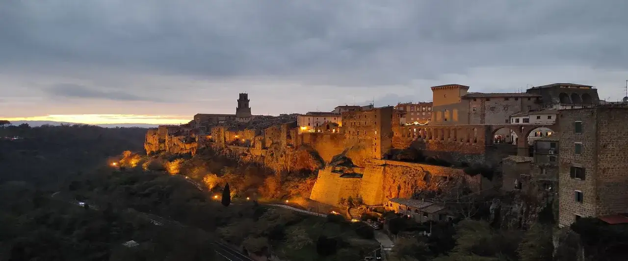 Pitigliano illuminata al tramonto, un borgo medievale arroccato su tufo. Ideale per scoprire cosa vedere a Pitigliano in mezza giornata.