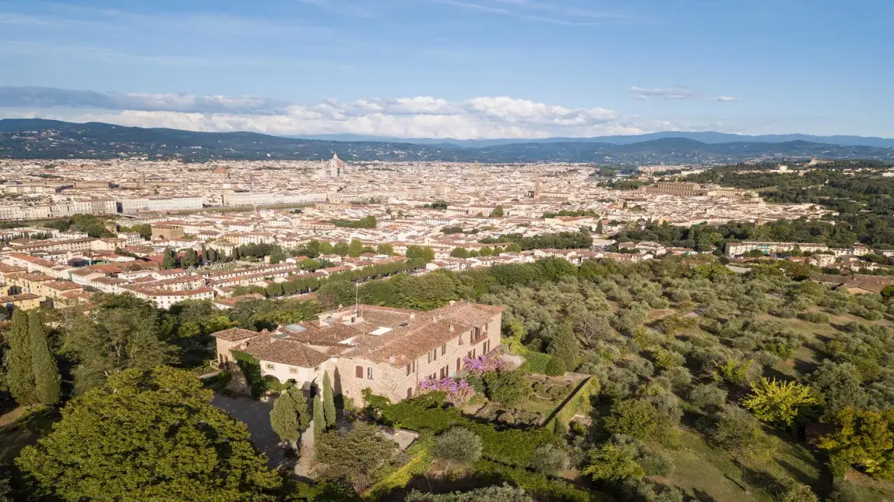 Vista aerea di una villa con giardino e uliveto, con Firenze sullo sfondo. Un'ottima meta per il trekking in Toscana.
