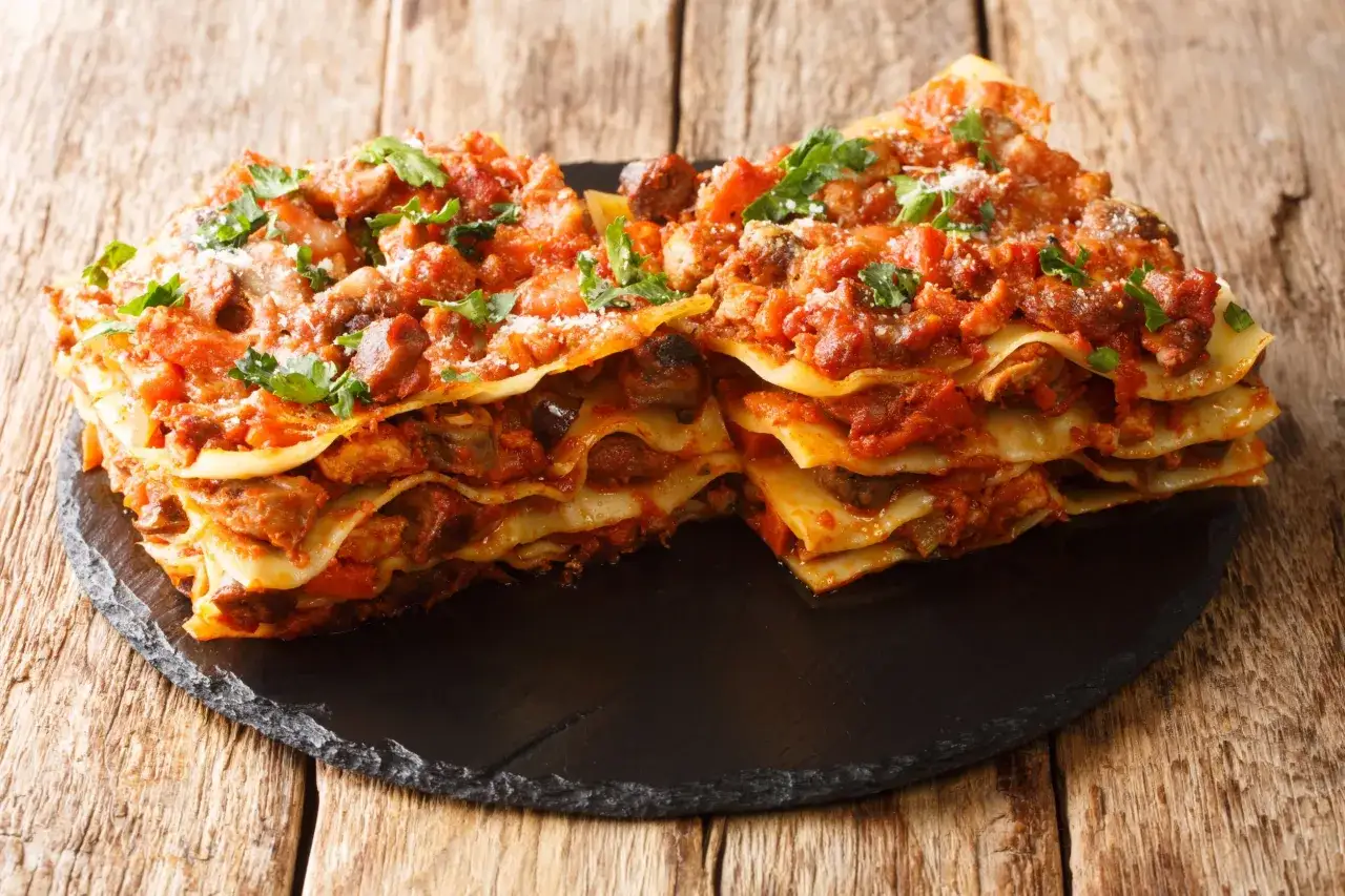 Lasagne ricche e saporite, un'ottima idea su cosa mangiare nelle Marche. Strati di pasta, ragù e formaggio, un piatto che conquista.