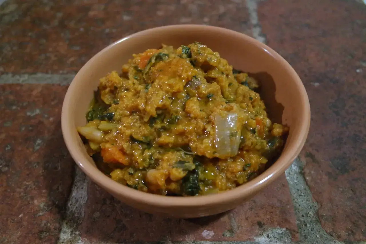 Una ciotola di ribollita senese, ricca e saporita, con pane raffermo, verdure e fagioli.