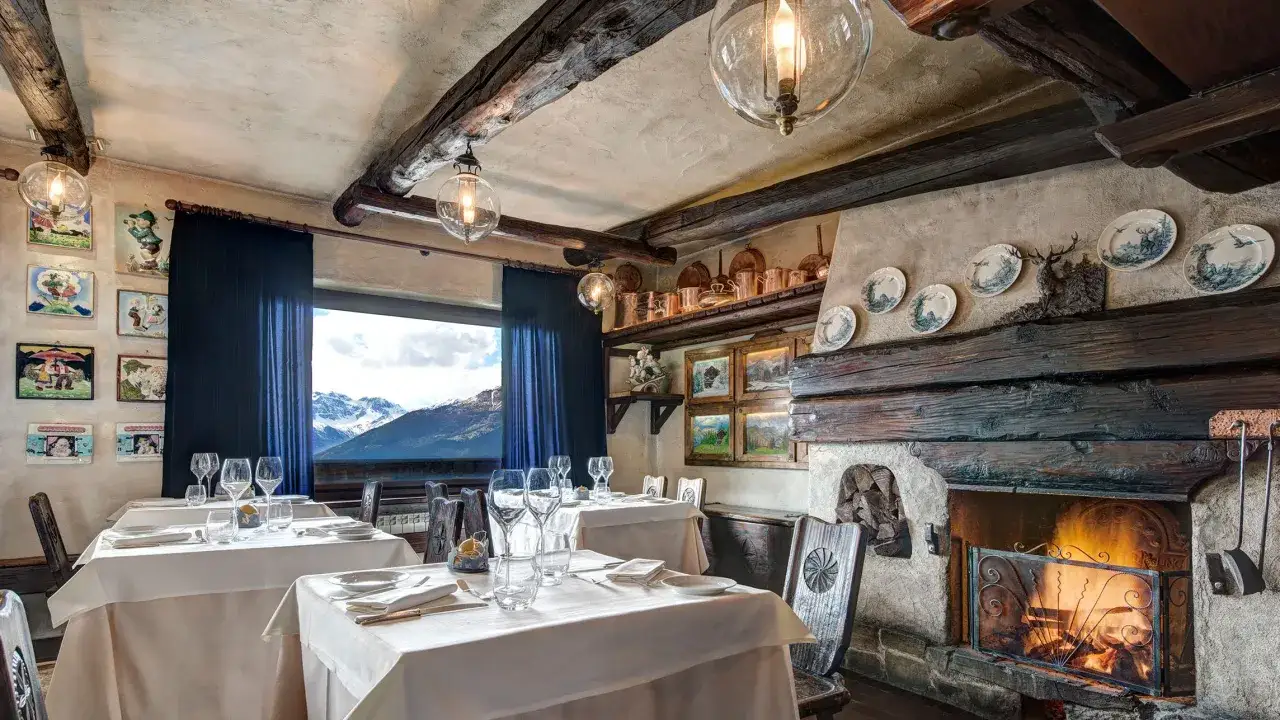 Tavoli apparecchiati in un accogliente agriturismo in Piemonte, ideale per un pranzo con vista sulle montagne.