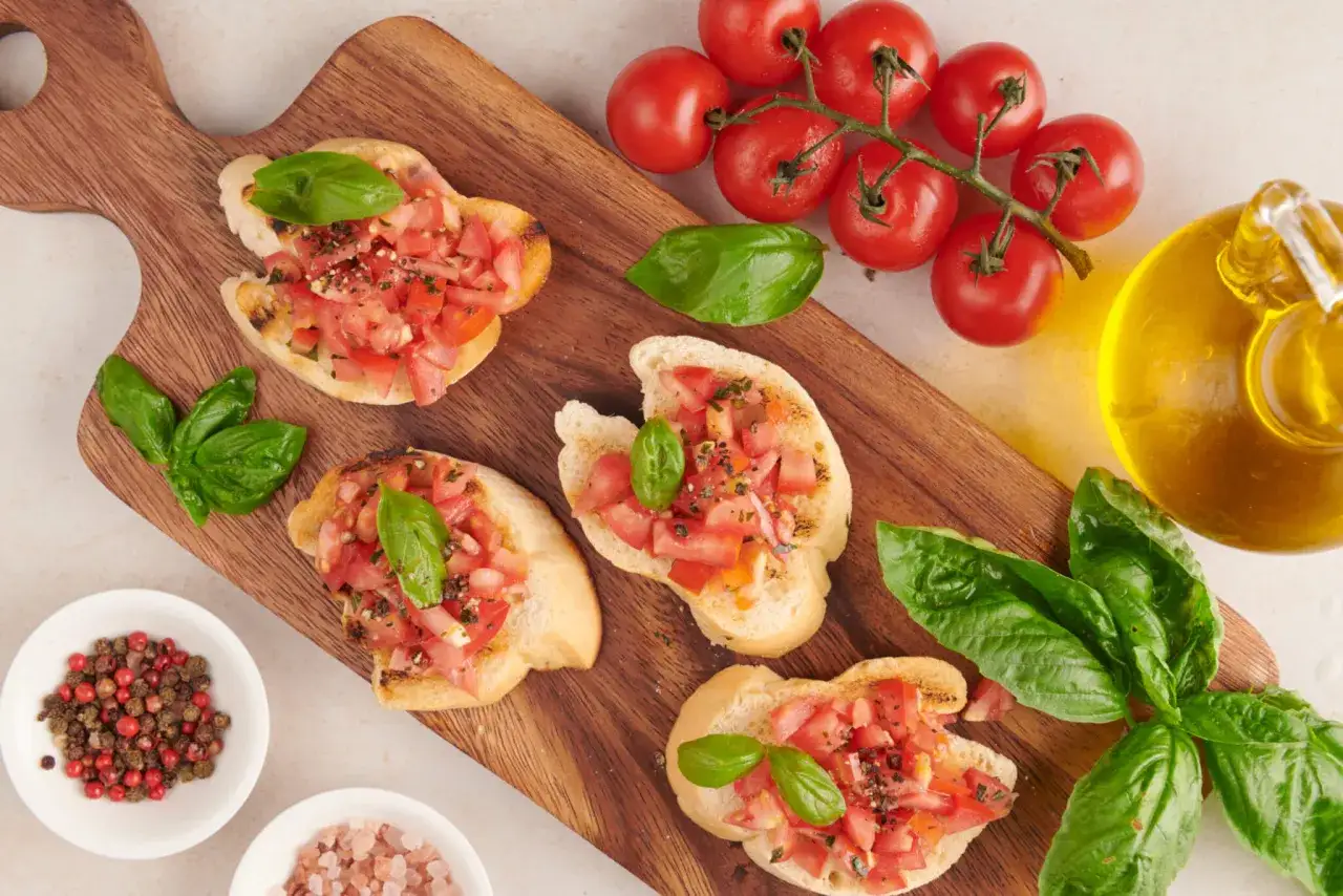 Bruschette con pomodoro fresco e basilico, un classico dei piatti tipici toscani estivi. Ingredienti semplici per un gusto autentico.