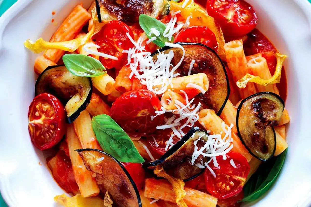 Pasta alla Norma, un classico su cosa mangiare in Sicilia: melanzane fritte, pomodoro fresco, ricotta salata e basilico.