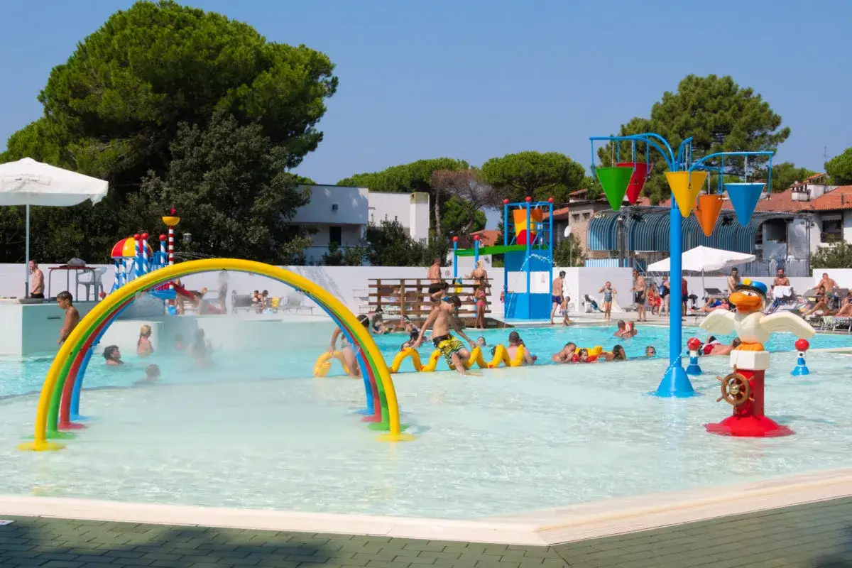 Bambini si divertono in una piscina con giochi d'acqua, ideale per campeggi in Toscana sul mare.