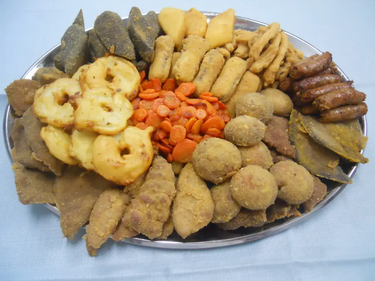 Vassoio con un assortimento di piatti tipici torinesi: frittelle, verdure, polpette e salumi.