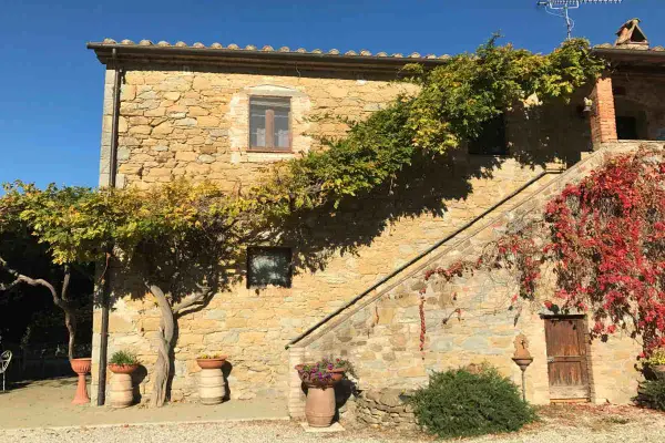 Agriturismi pet friendly in Umbria: casa in pietra con scala esterna e rampicanti colorati, ideale per vacanze con animali.